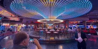 Dealer casino live tersenyum dan melayani pemain melalui streaming video berkualitas tinggi